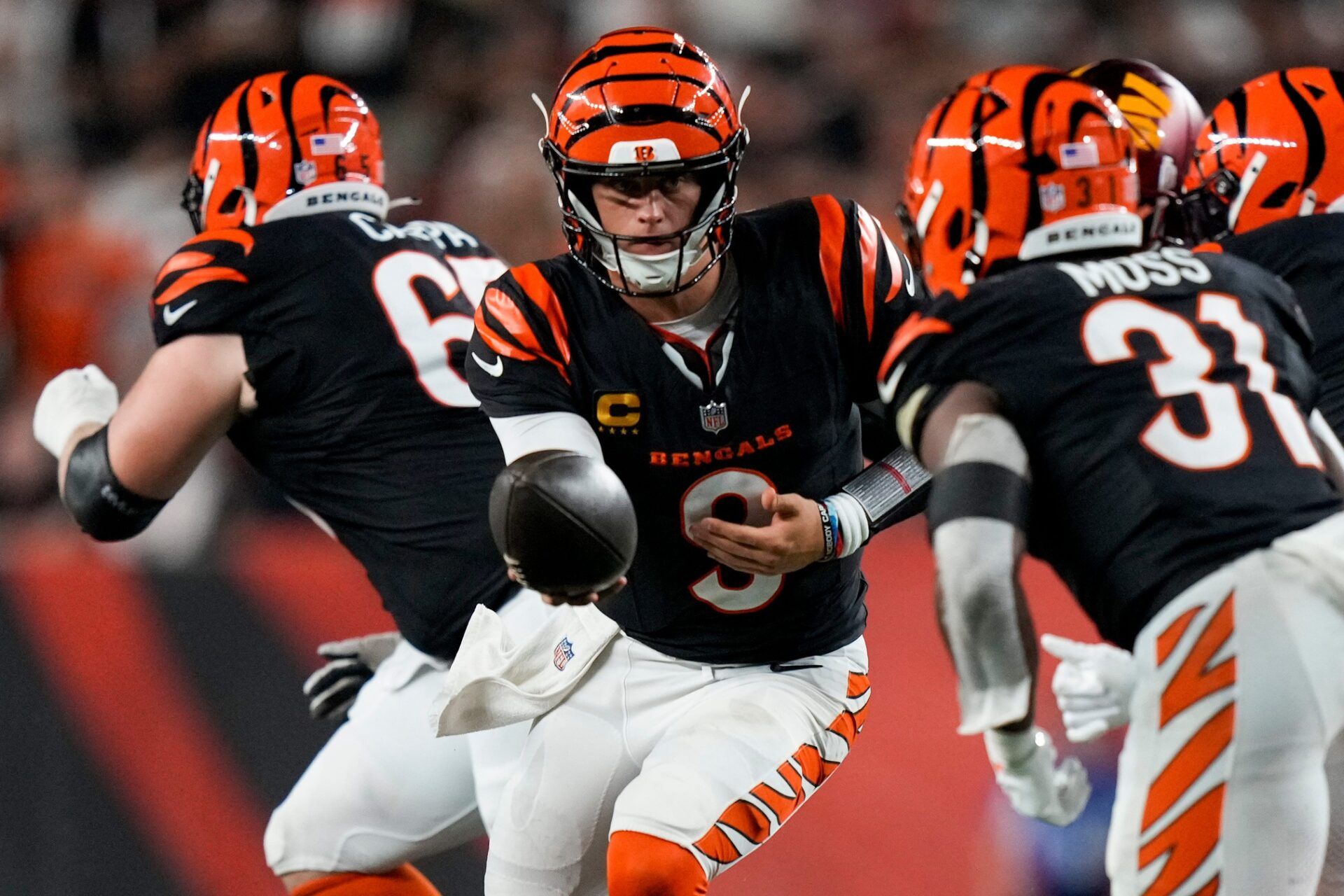 Cincinnati Bengals quarterback Joe Burrow (9) hands off to running back Zack Moss (31) in the fourth quarter of the NFL Week 3 game between the Cincinnati Bengals and the Washington Commanders at Paycor Stadium in downtown Cincinnati on Monday, Sept. 23, 2024. The Bengals remain winless after a 38-33 loss to Washington.