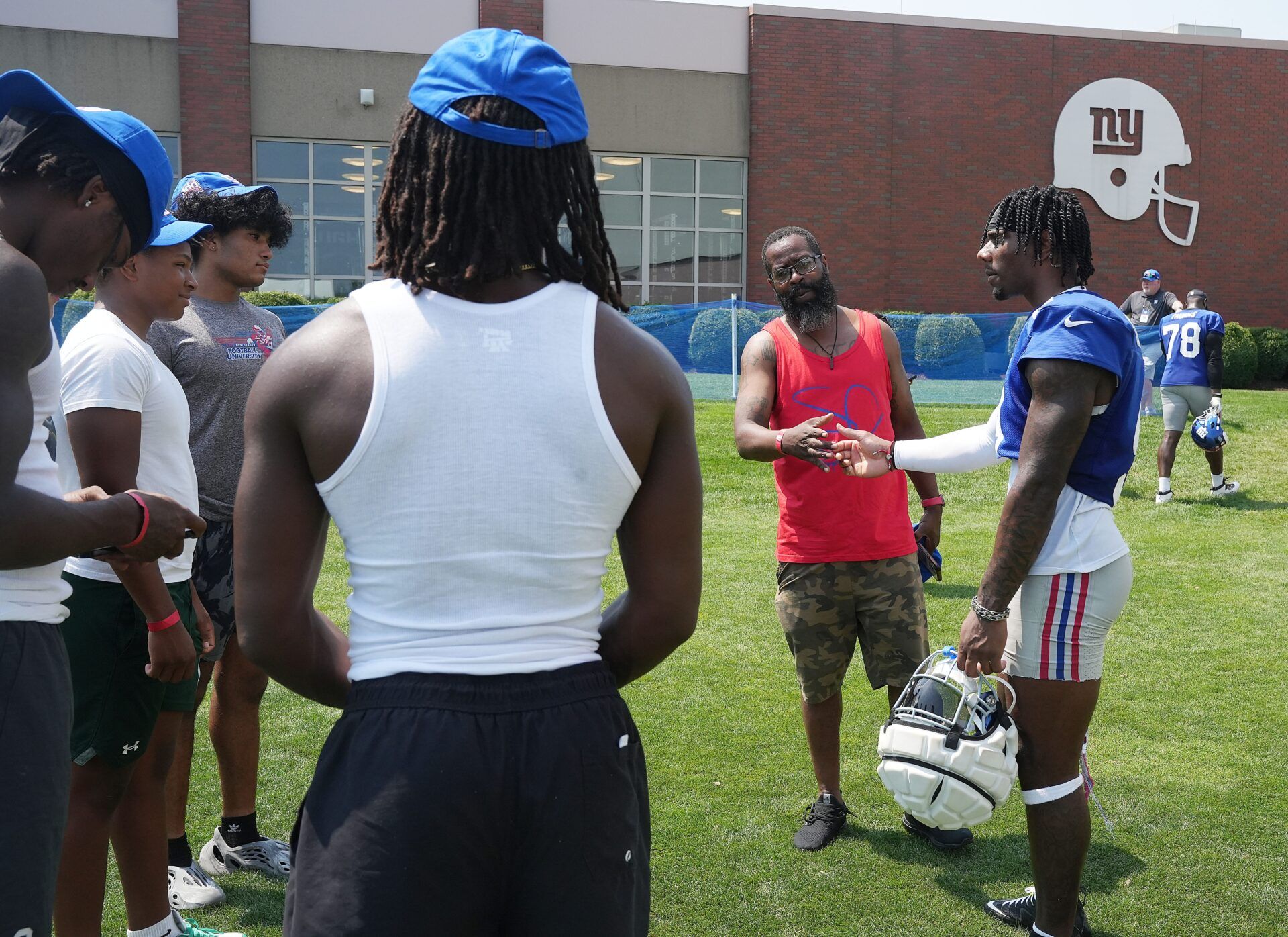 East Rutherford, NJ -- August 1, 2024 -- Jarrod Rogers of Paterson, second from right, an assistant coach at DePaul, with Malik Nabers after practice at training camp for the New York Giants.