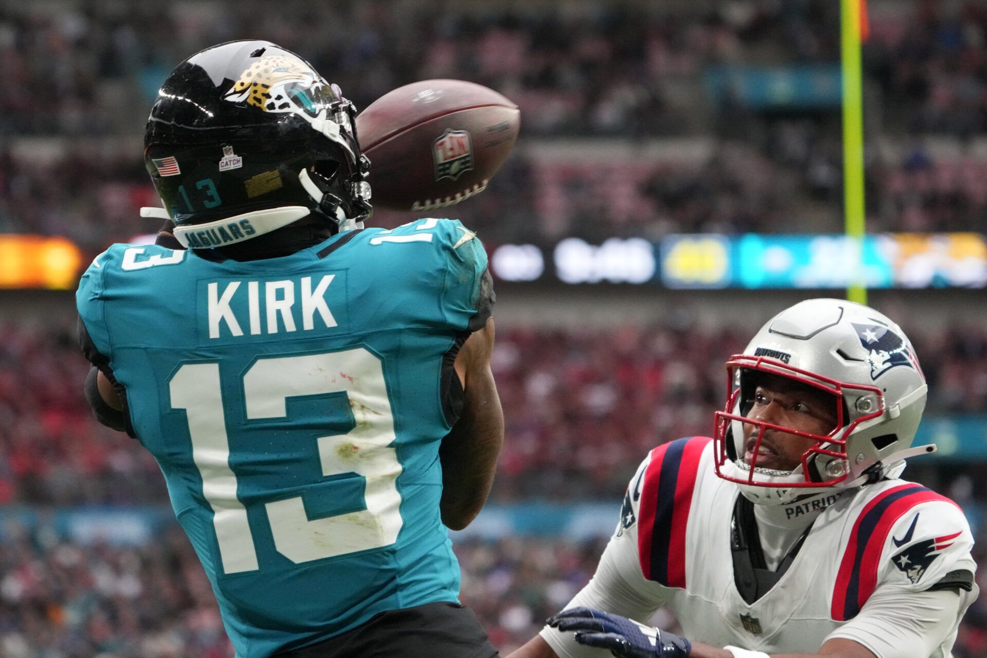 Jacksonville Jaguars wide receiver Christian Kirk (13) attempts to catch the ball against New England Patriots cornerback Marcus Jones (25) in the second half of an NFL International Series game at Wembley Stadium.
