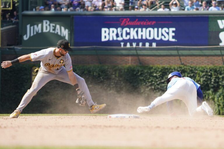 Chicago Cubs outfielder Pete Crow-Armstrong (4) is tagged out on a steal attempt of second base by Pittsburgh Pirates shortstop Jared Triolo (19) during the ninth inning at Wrigley Field.