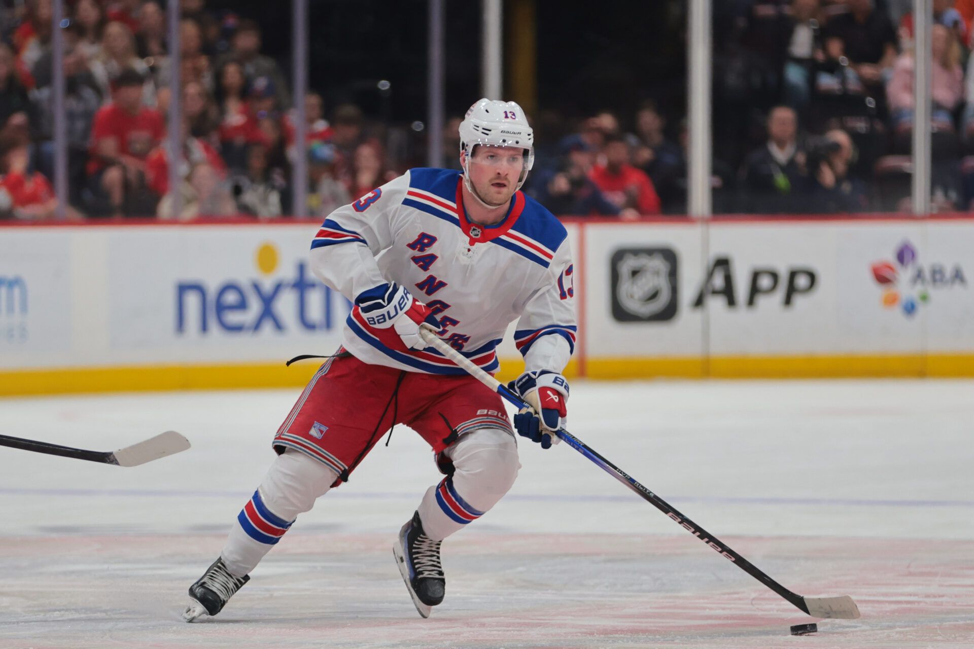 New York Rangers left wing Alexis Lafreniere (13) moves the puck against the Florida Panthers during the first period at Amerant Bank Arena.