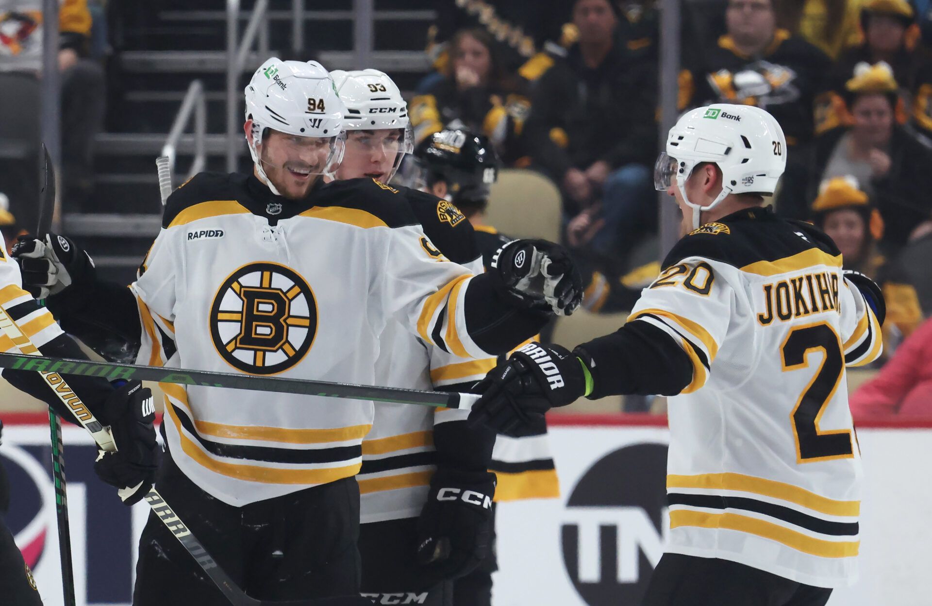 Boston Bruins center Jakub Lauko (94) celebrates his empty net goal with defenseman Henri Jokiharju (20) against the Pittsburgh Penguins during the third period at PPG Paints Arena.