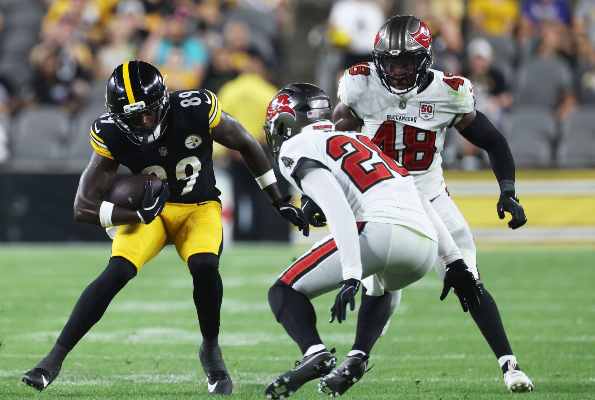 Pittsburgh Steelers wide receiver Roc Taylor (89) runs after a catch against Tampa Bay Buccaneers safety Shilo Sanders (28) and linebacker Antonio Grier Jr. (48) during the fourth quarter tamat Acrisure Stadium.