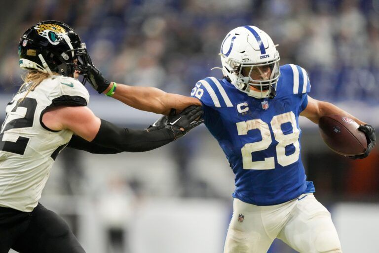 Indianapolis Colts running back Jonathan Taylor (28) pushes off Jacksonville Jaguars cornerback De'Antre Prince (24) as he rushes the ball Sunday, Jan. 5, 2025, during a game against the Jacksonville Jaguars at Lucas Oil Stadium in Indianapolis.