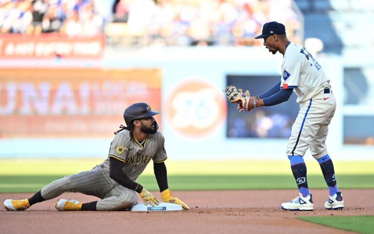 Los Angeles Dodgers shortstop Mookie Betts (50) takes out San Diego Padres outfielder Fernando Tatis Jr. (23) at second base during the first inning at Dodger Stadium.