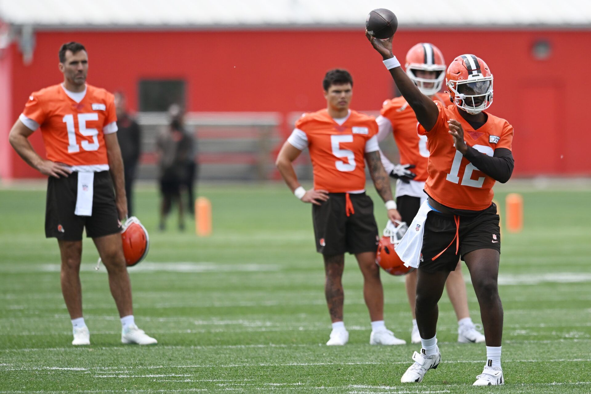 Cleveland Browns quarterback Shedeur Sanders (12) throws a pass as quarterback Joe Flacco (15) and quarterback Dillon Gabriel (5) and quarterback Kenny Pickett (8) look on during minicamp at CrossCountry Mortgage Campus.