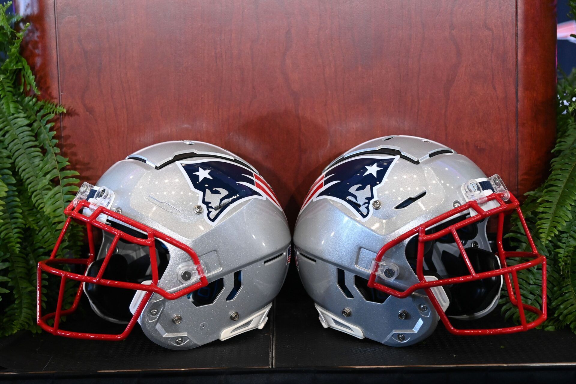 A pair of New England Patriots helmets sit in front of the podium before a press conference at Gillette Stadium.