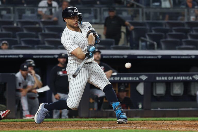 New York Yankees right fielder Giancarlo Stanton (27) singles during the ninth inning against the Minnesota Twins at Yankee Stadium.