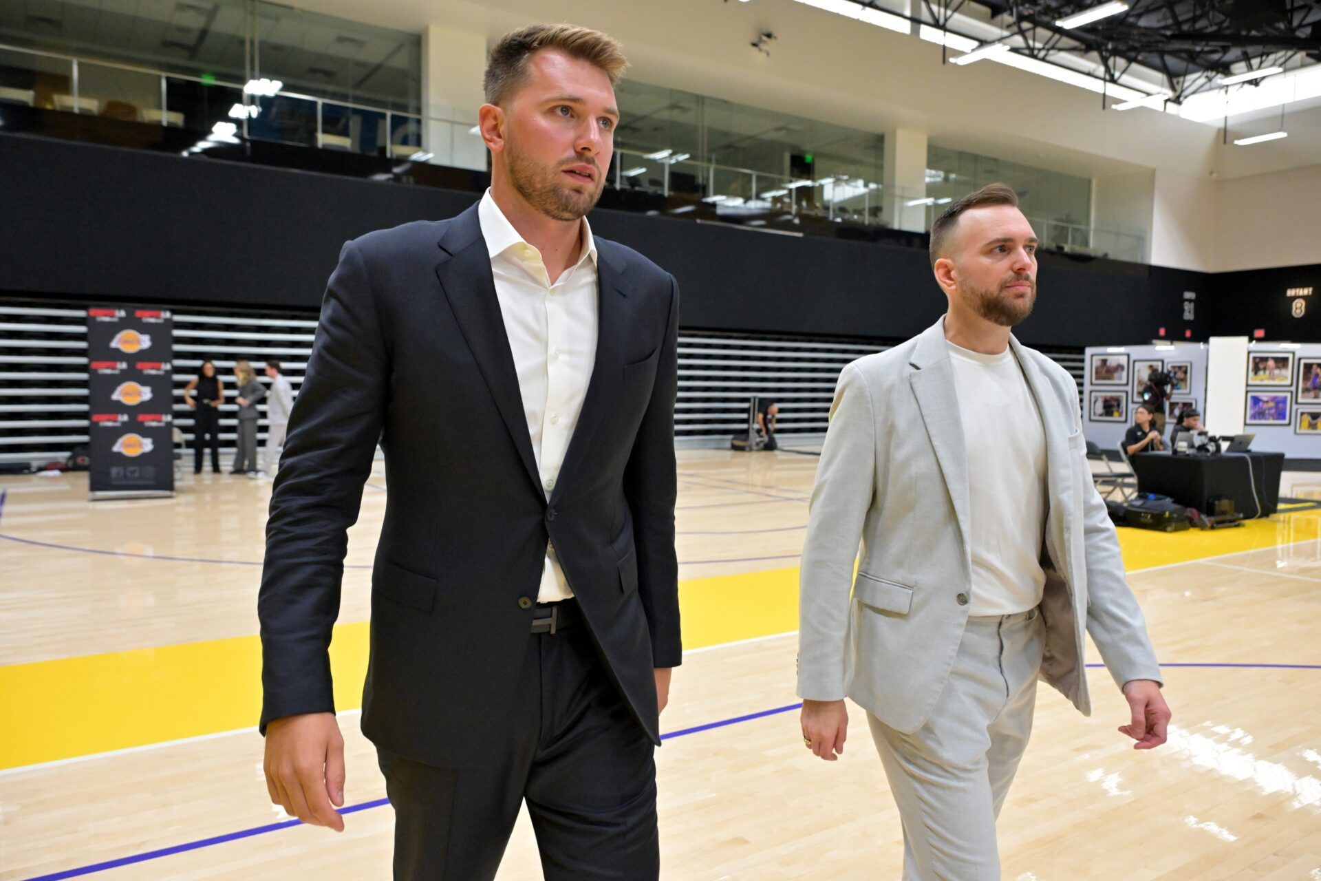 Los Angeles Lakers Luka Doncic (77) walks with team communications director Mitch Heckart following a press conference announcing the signing of a 3-year, $165 million contract extension at UCLA Health Training Center.