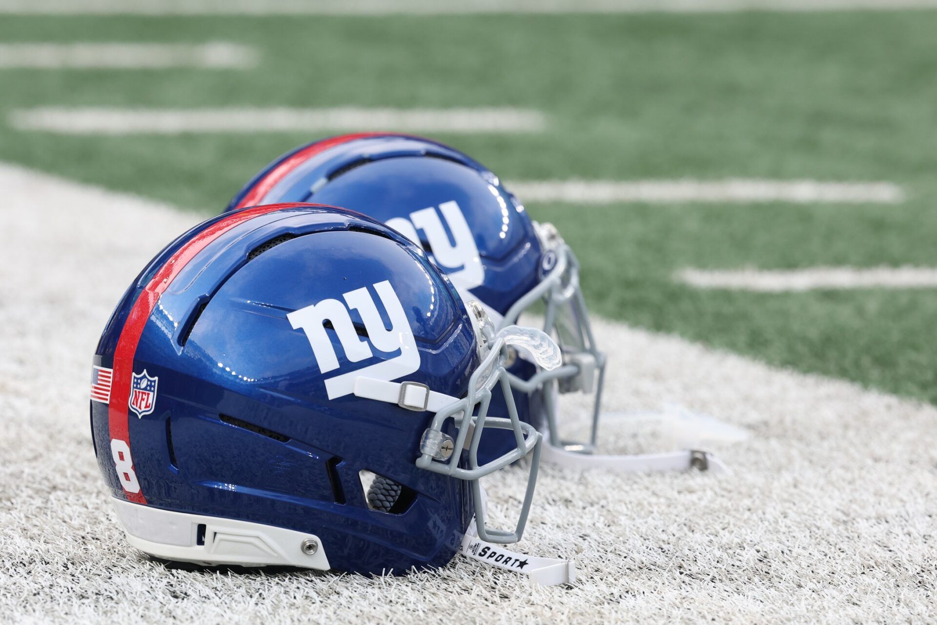 New York Giants helmets rest on the field before the preseason game against the New York Jets at MetLife Stadium.