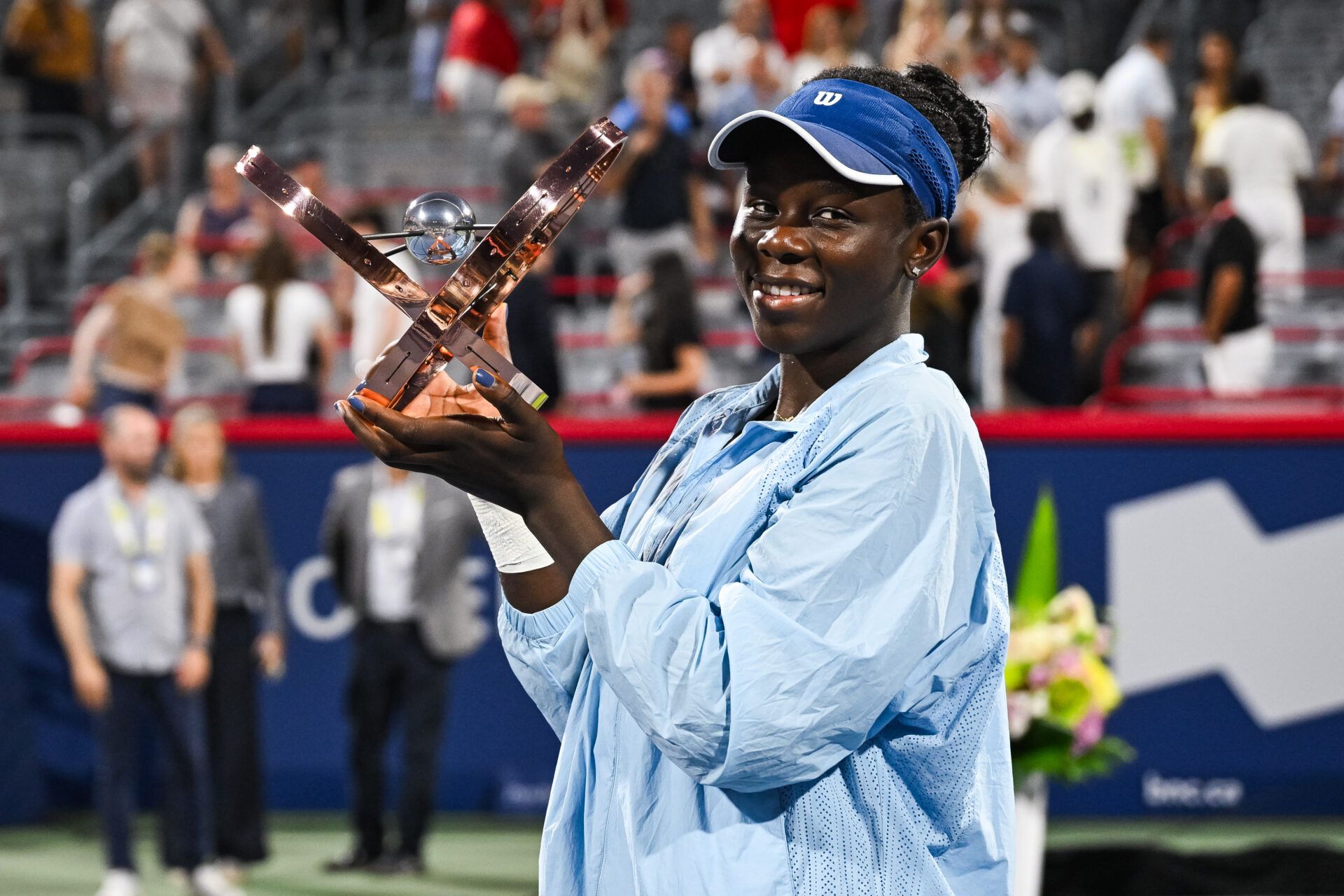 Victoria Mboko (CAN) tournament winner against Naomi Osaka (JPN) holds her trophy at IGA Stadium.