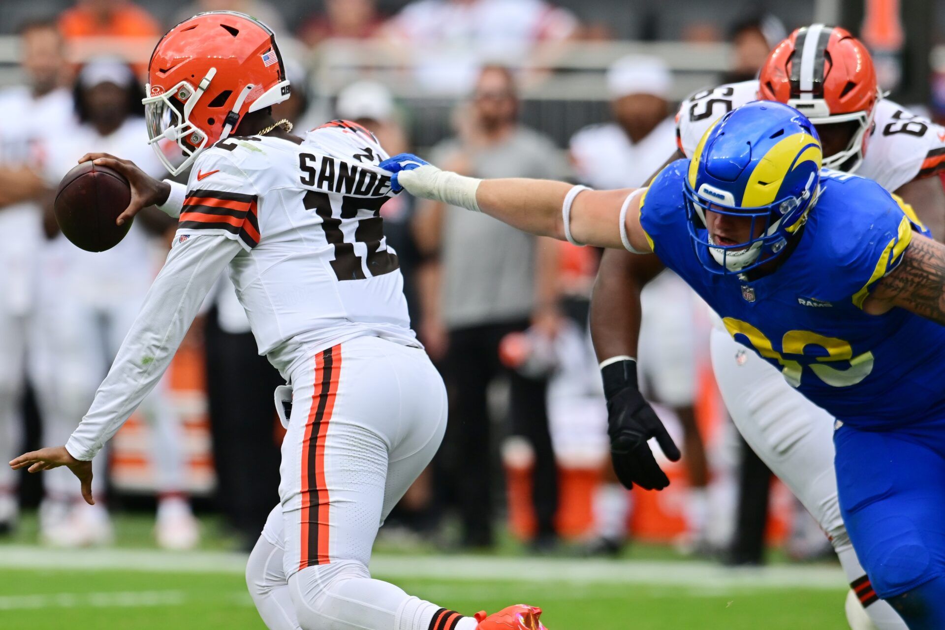 Los Angeles Rams defensive tackle Jack Heflin (93) grabs the jersey of Cleveland Browns quarterback Shedeur Sanders (12) during the second half at Huntington Bank Field.