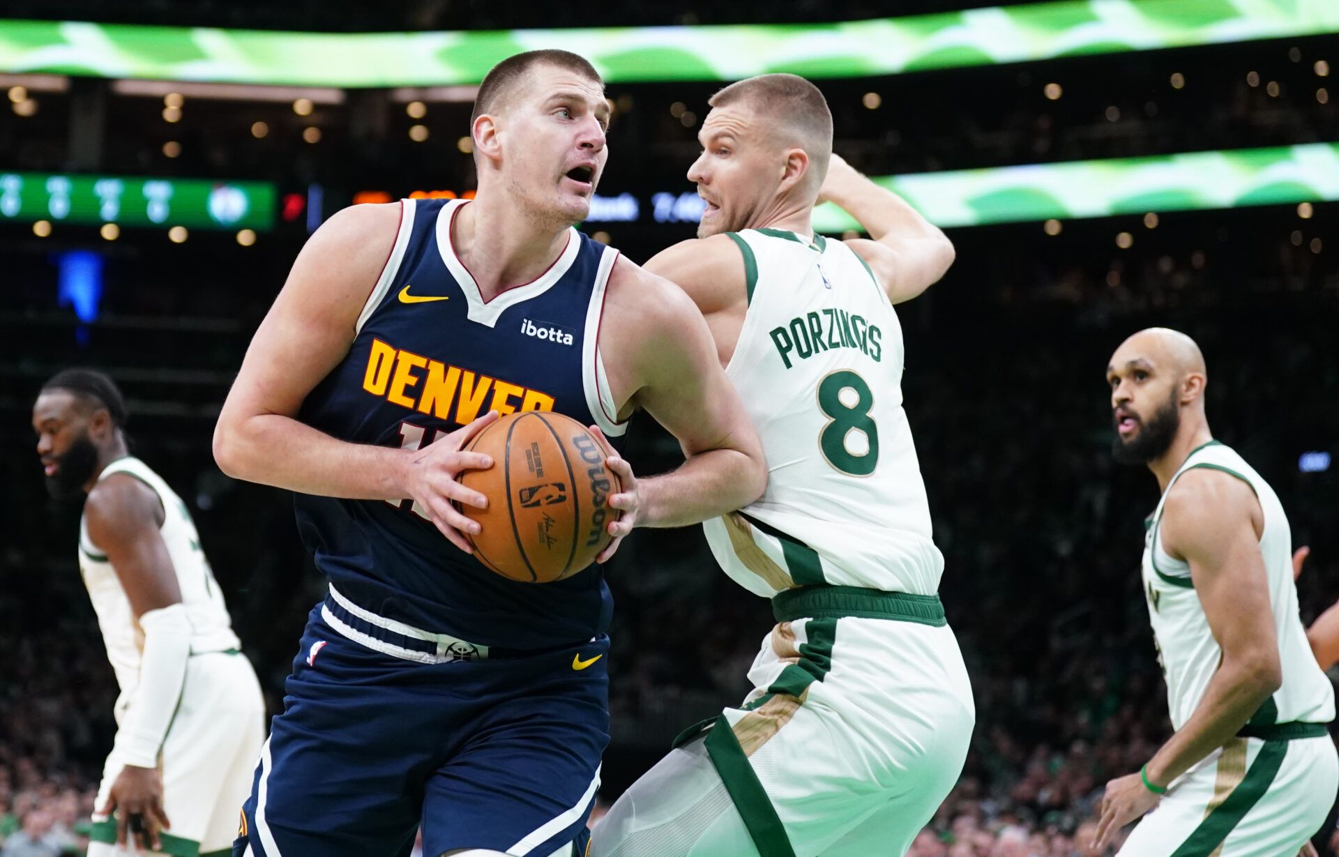 Denver Nuggets center Nikola Jokic (15) moves the ball against Boston Celtics center Kristaps Porzingis (8) in the first quarter at TD Garden.