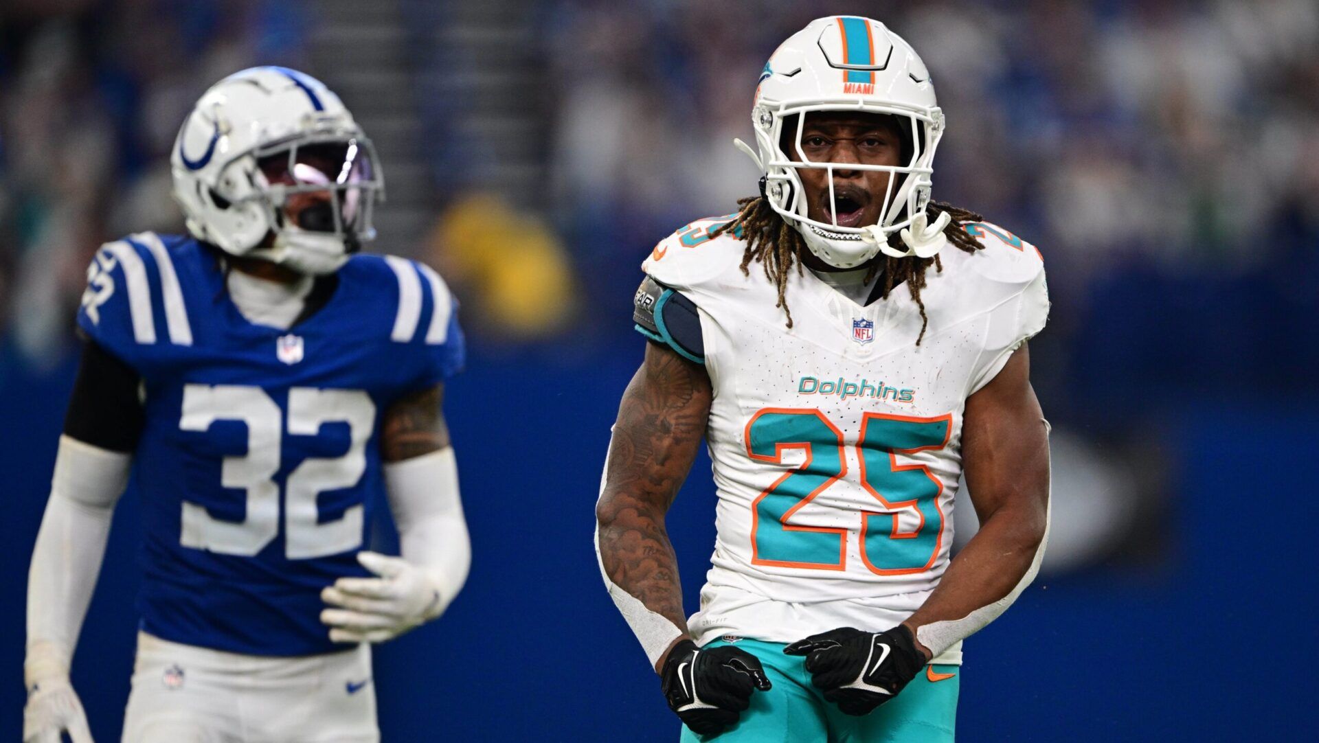 Miami Dolphins running back Jaylen Wright (25) celebrates a long run in front of Indianapolis Colts safety Julian Blackmon (32) during the second half at Lucas Oil Stadium.