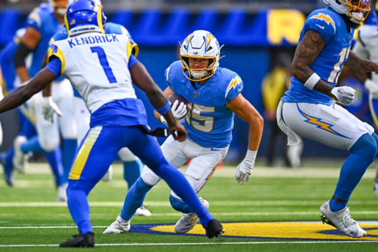 Los Angeles Chargers wide receiver Ladd McConkey (15) runs the ball against Los Angeles Rams cornerback Derion Kendrick (1) during the first quarter at SoFi Stadium.
