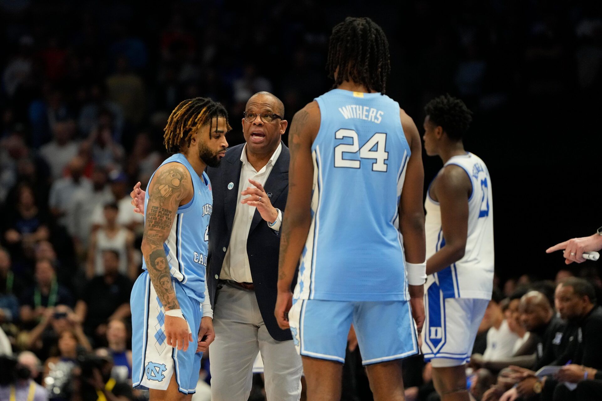 North Carolina Tar Heels head coach Hubert Davis talks with guard RJ Davis (4) as forward Jae'Lyn Withers (24) looks on in the second half at Spectrum Center.