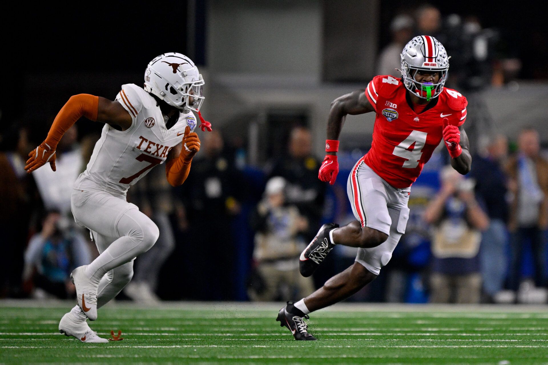 Ohio State Buckeyes wide receiver Jeremiah Smith (4) and Texas Longhorns defensive back Jahdae Barron (7) in action during the game between the Texas Longhorns and the Ohio State Buckeyes at AT&T Stadium.