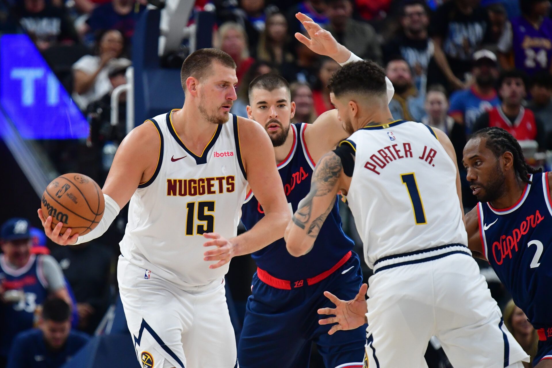 Denver Nuggets center Nikola Jokic (15) passes the ball to forward Michael Porter Jr. (1) against Los Angeles Clippers center Ivica Zubac (40) during the second half of game three in the first round for the 2024 NBA Playoffs at Intuit Dome.