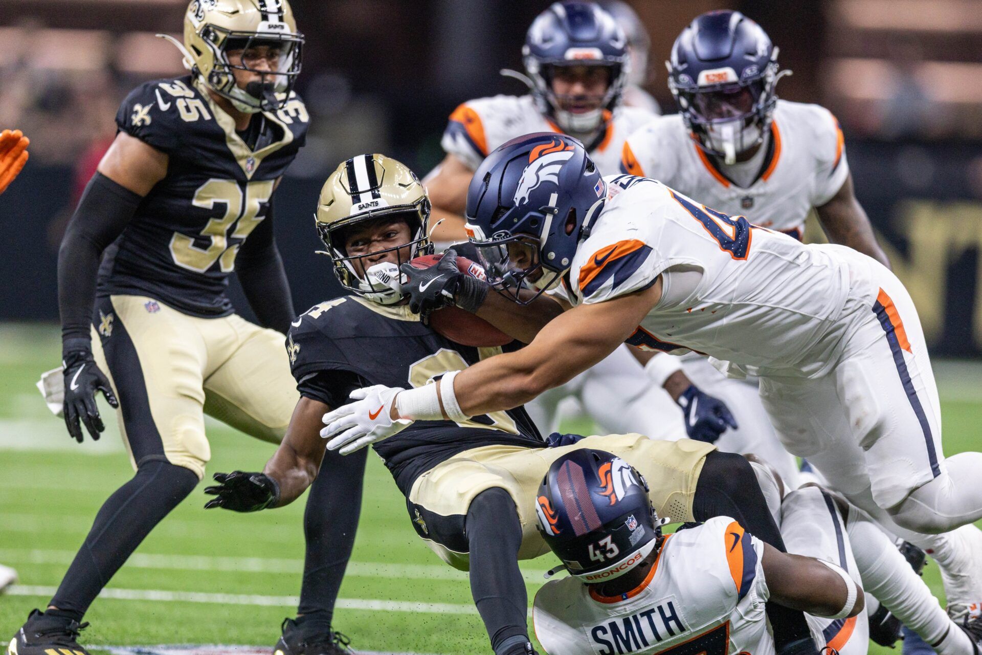 Denver Broncos safety Keidron Smith (43) tackles New Orleans Saints wide receiver Moochie Dixon (84) during the second half at Caesars Superdome.