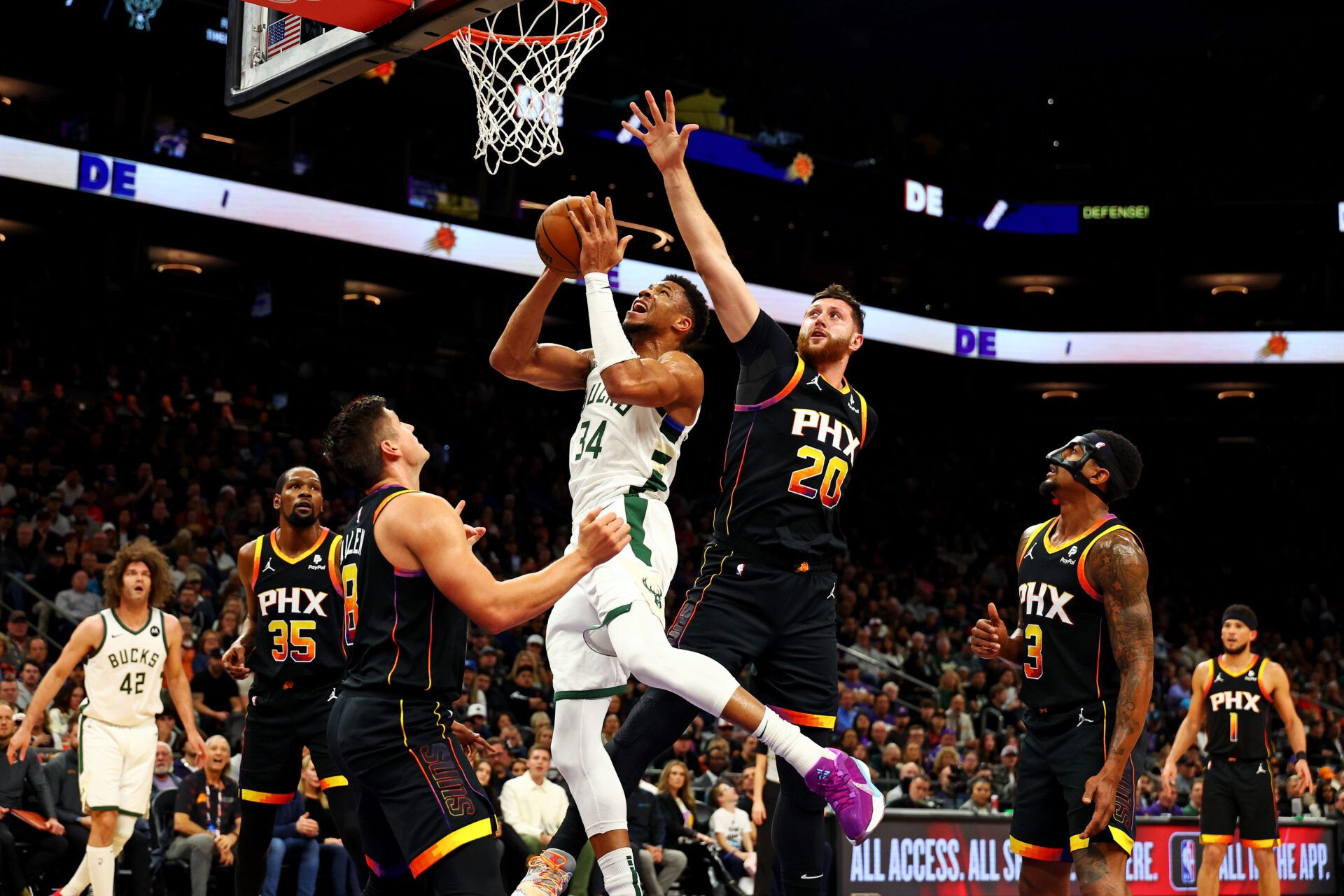 Milwaukee Bucks forward Giannis Antetokounmpo (34) shoots the ball against Phoenix Suns center Jusuf Nurkic (20) and guard Grayson Allen (8) during the first quarter at Footprint Center.