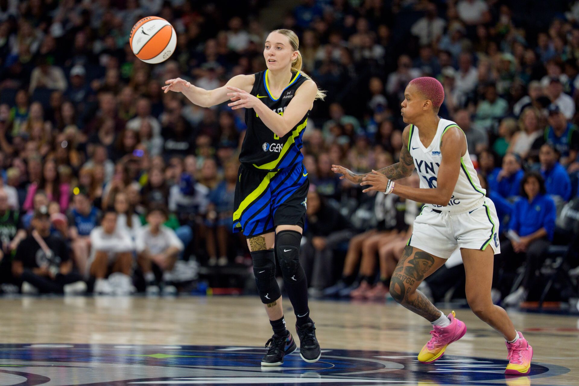 Dallas Wings guard Paige Bueckers (5) passes by the defense of Minnesota Lynx guard Courtney Williams (10) in the fourth quarter at Target Center.