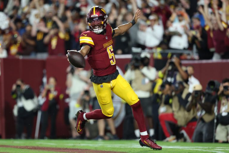 Washington Commanders quarterback Jayden Daniels (5) celebrates after scoring a touchdown against Cincinnati Bengals during the first half at Northwest Stadium.
