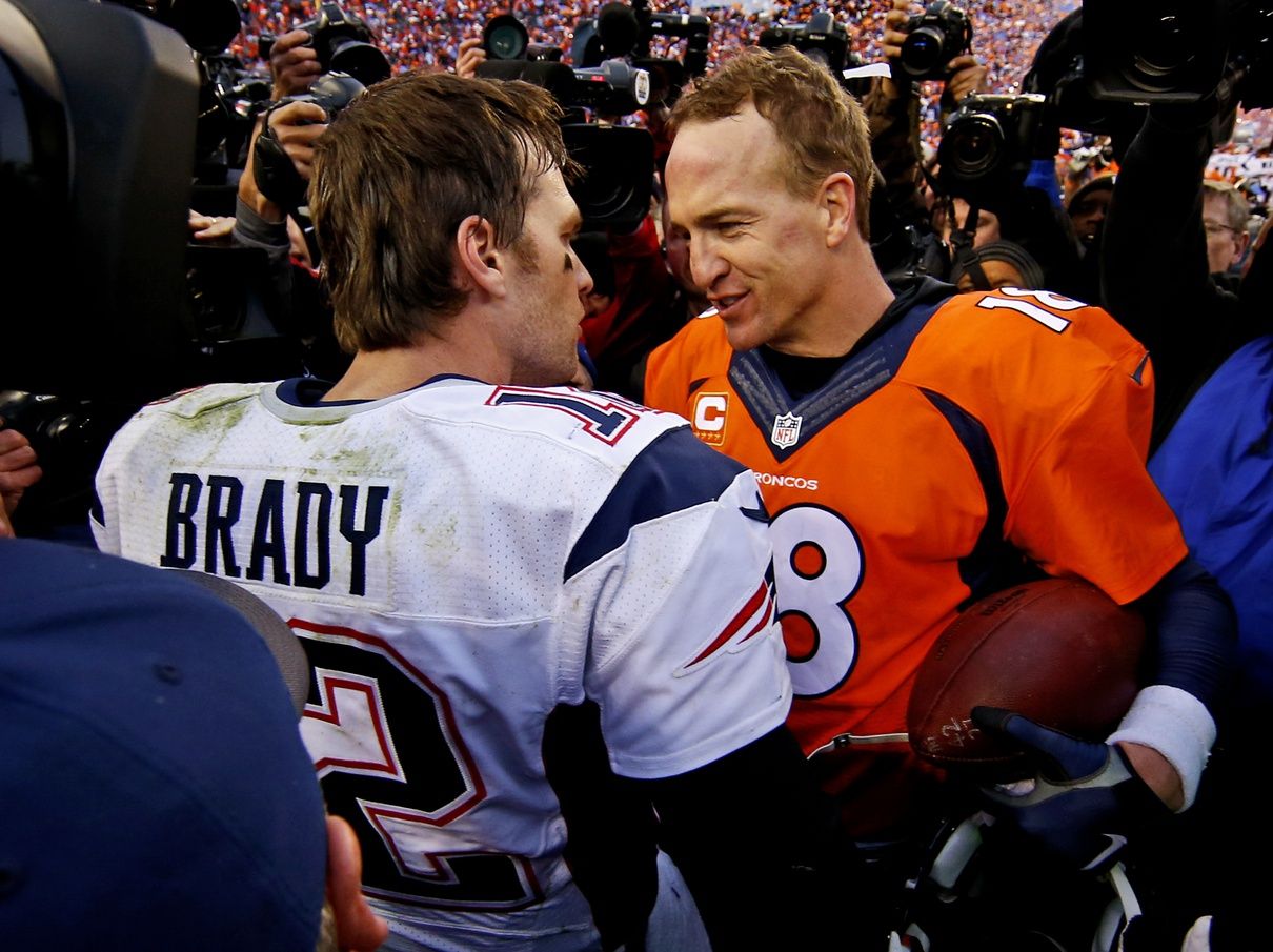 New England Patriots quarterback Tom Brady (12) and Denver Broncos quarterback Peyton Manning (18) shake hands after the game in the AFC Championship football game at Sports Authority Field at Mile High.