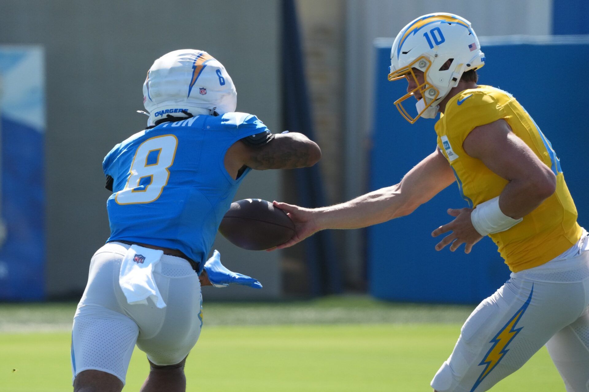 Los Angeles Chargers quarterback Justin Herbert (10) hands the ball off to running back Omarion Hampton (8) during training camp at The Bolt.