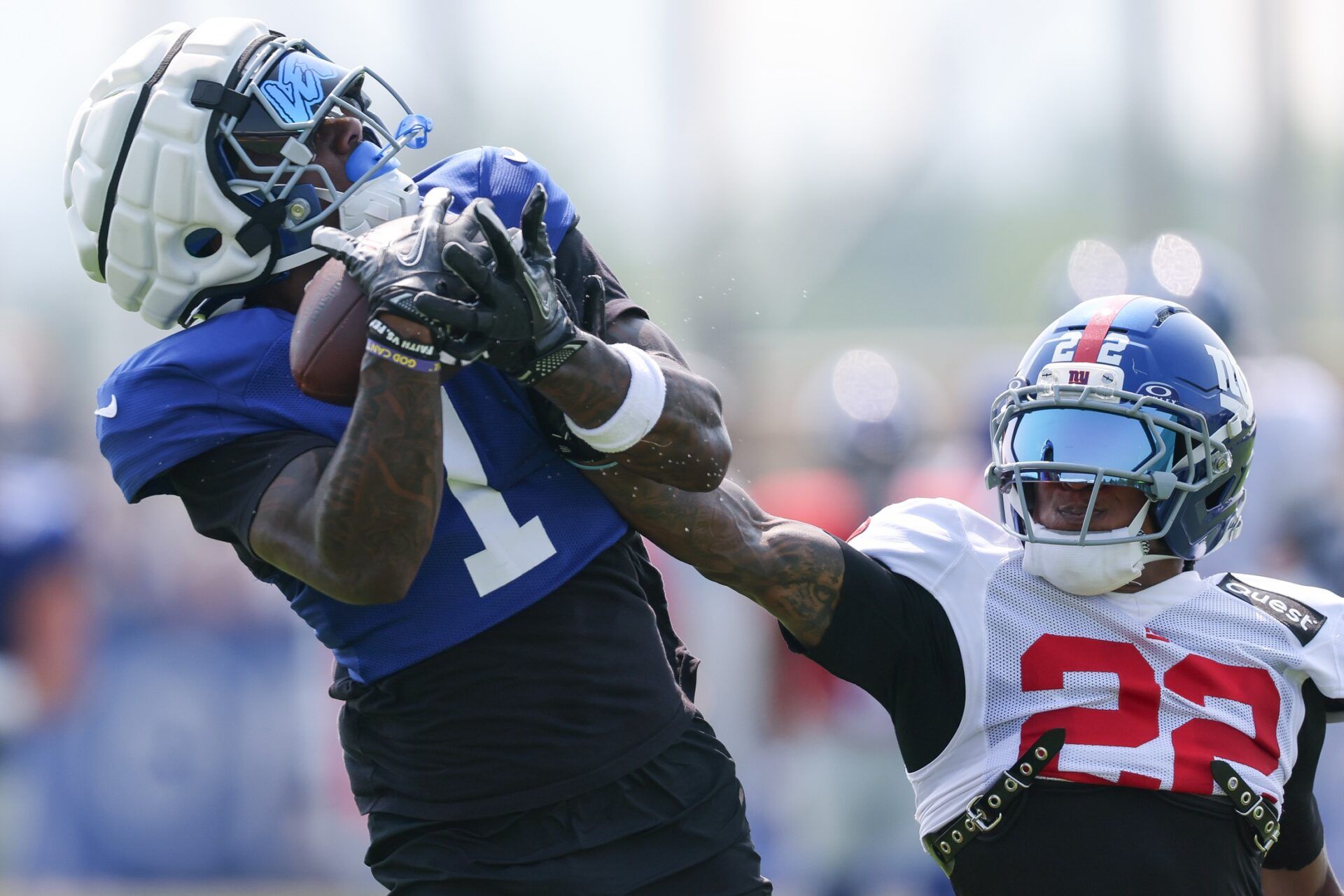 New York Giants wide receiver Malik Nabers (1) catches the ball as cornerback Dru Phillips (22) defends during training camp at Quest Diagnostics Training Center.