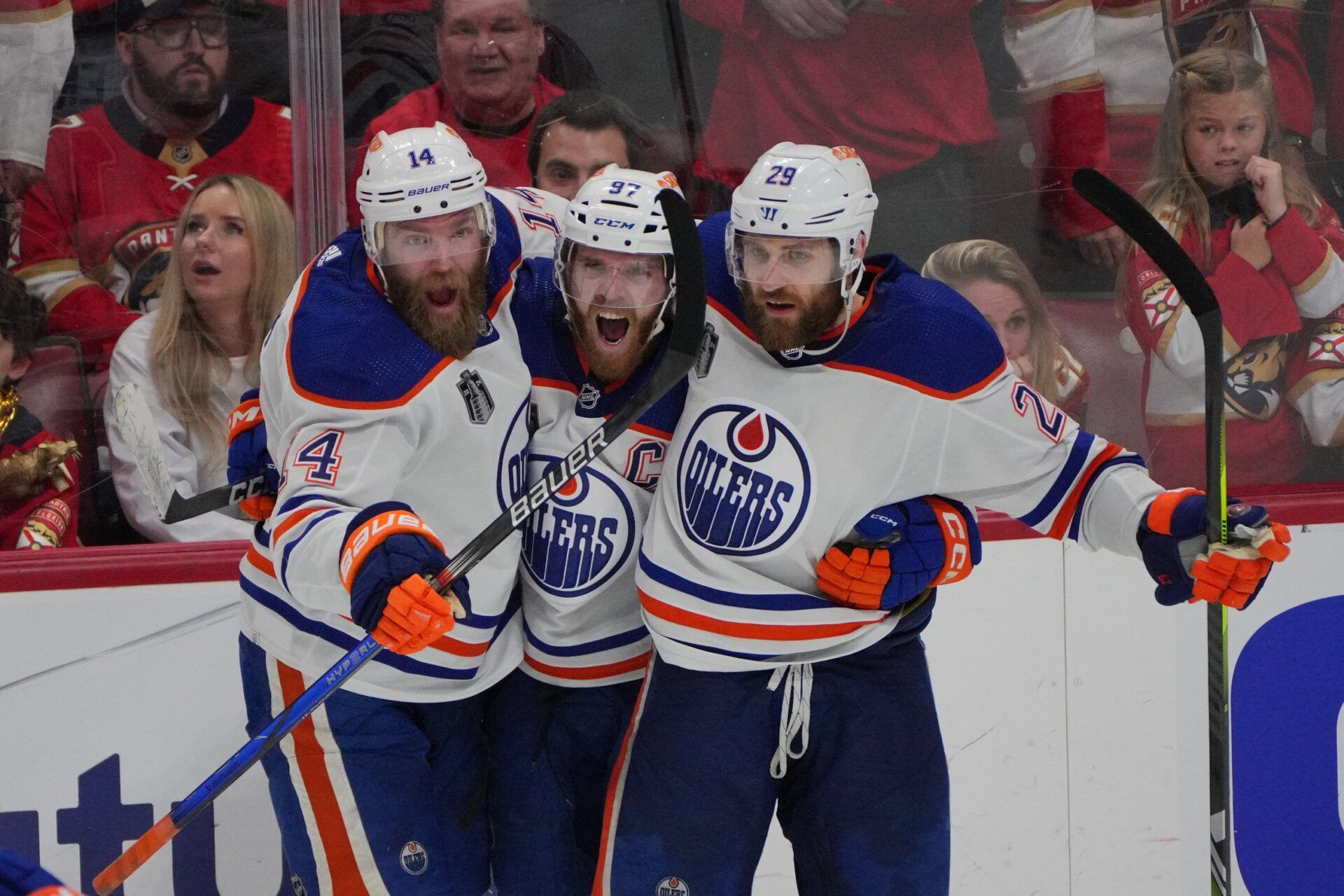 Edmonton Oilers forward Connor McDavid (97) celebrates scoring an empty net goal with defenseman Mattias Ekholm (14) and forward Adam Henrique (19) during the third period against the Florida Panthers in game five of the 2024 Stanley Cup Final at Amerant Bank Arena.