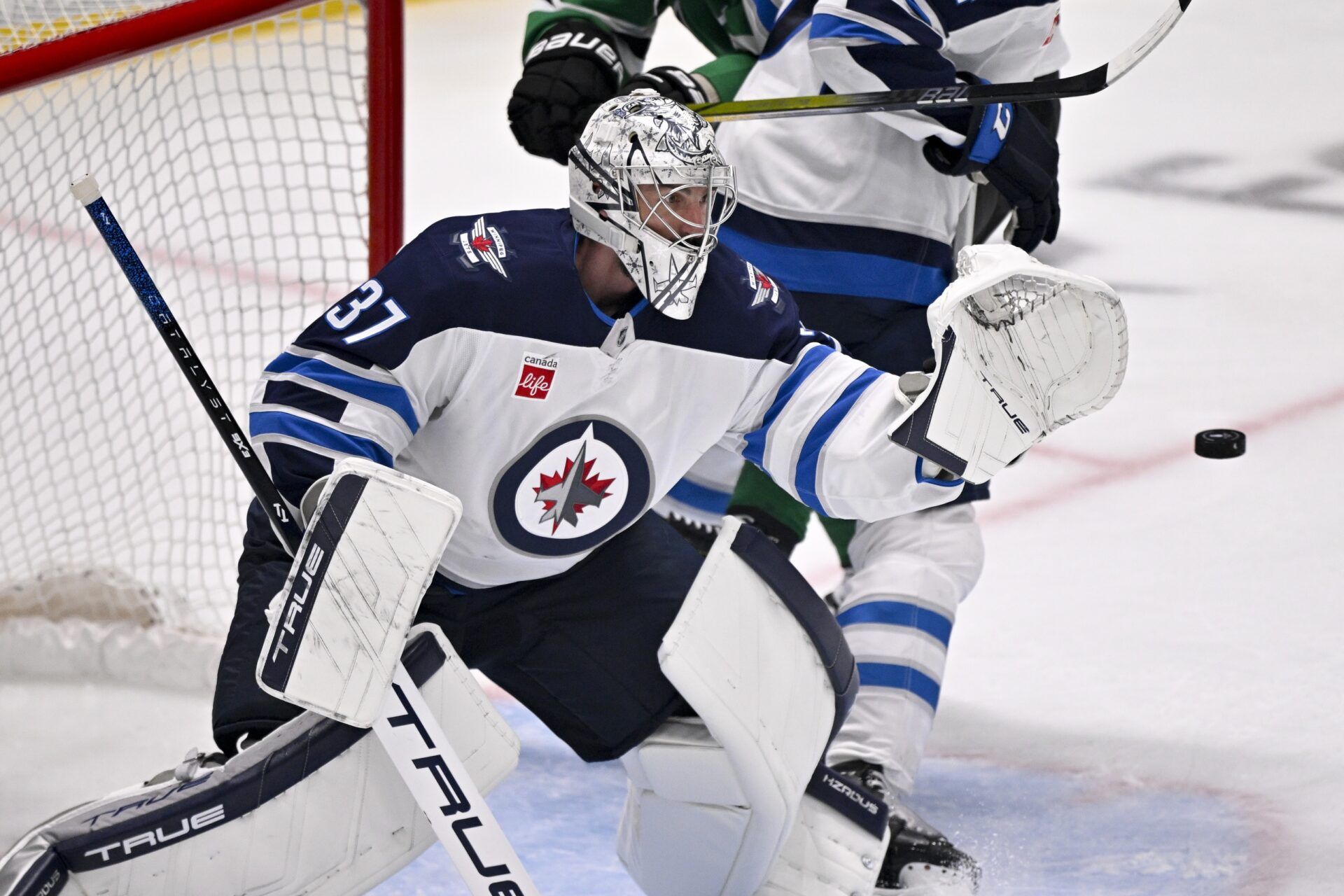 Winnipeg Jets goaltender Connor Hellebuyck (37) makes a glove save on a Dallas Stars shot during the third period in game six of the second round of the 2025 Stanley Cup Playoffs at American Airlines Center.