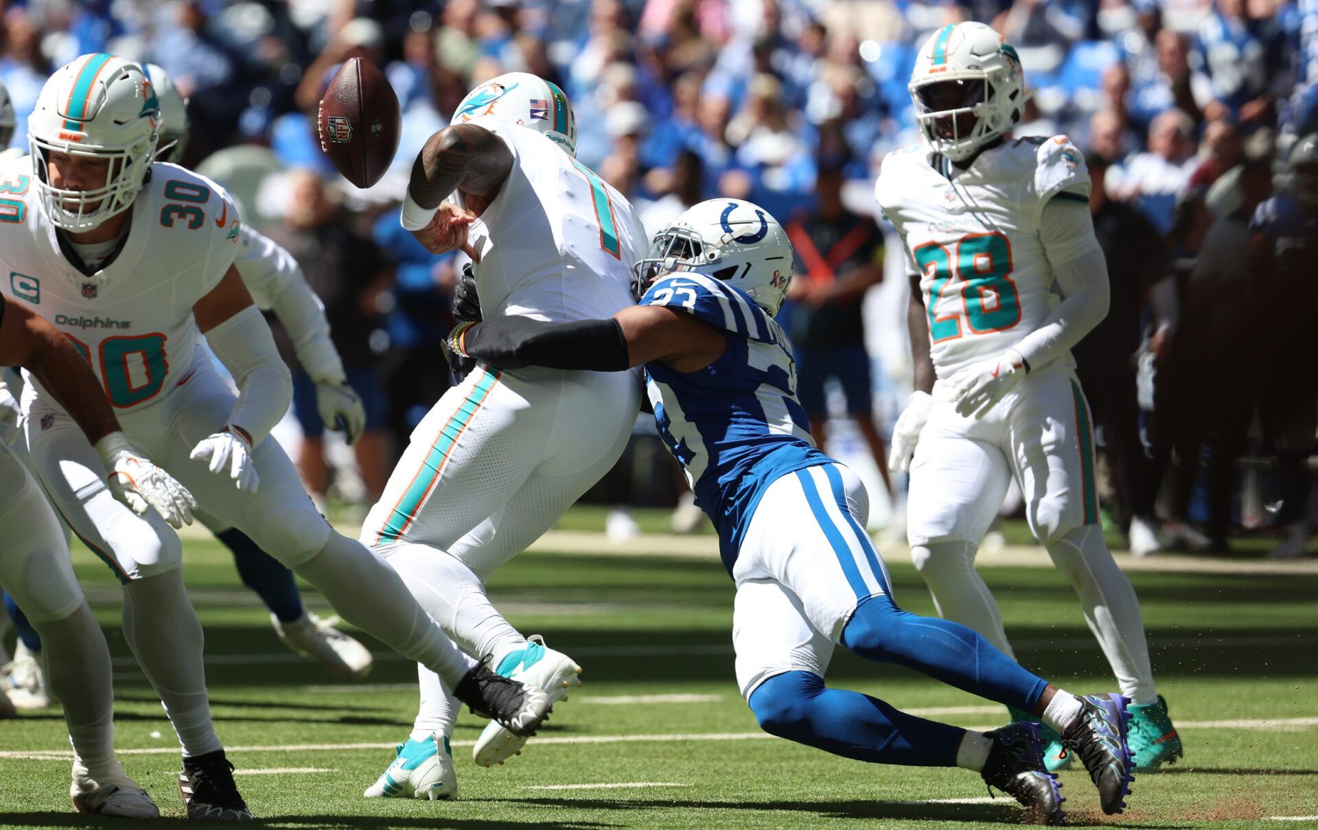 Indianapolis Colts cornerback Kenny Moore II (23) causes a fumble by Miami Dolphins quarterback Tua Tagovailoa (1) during the first half at Lucas Oil Stadium.