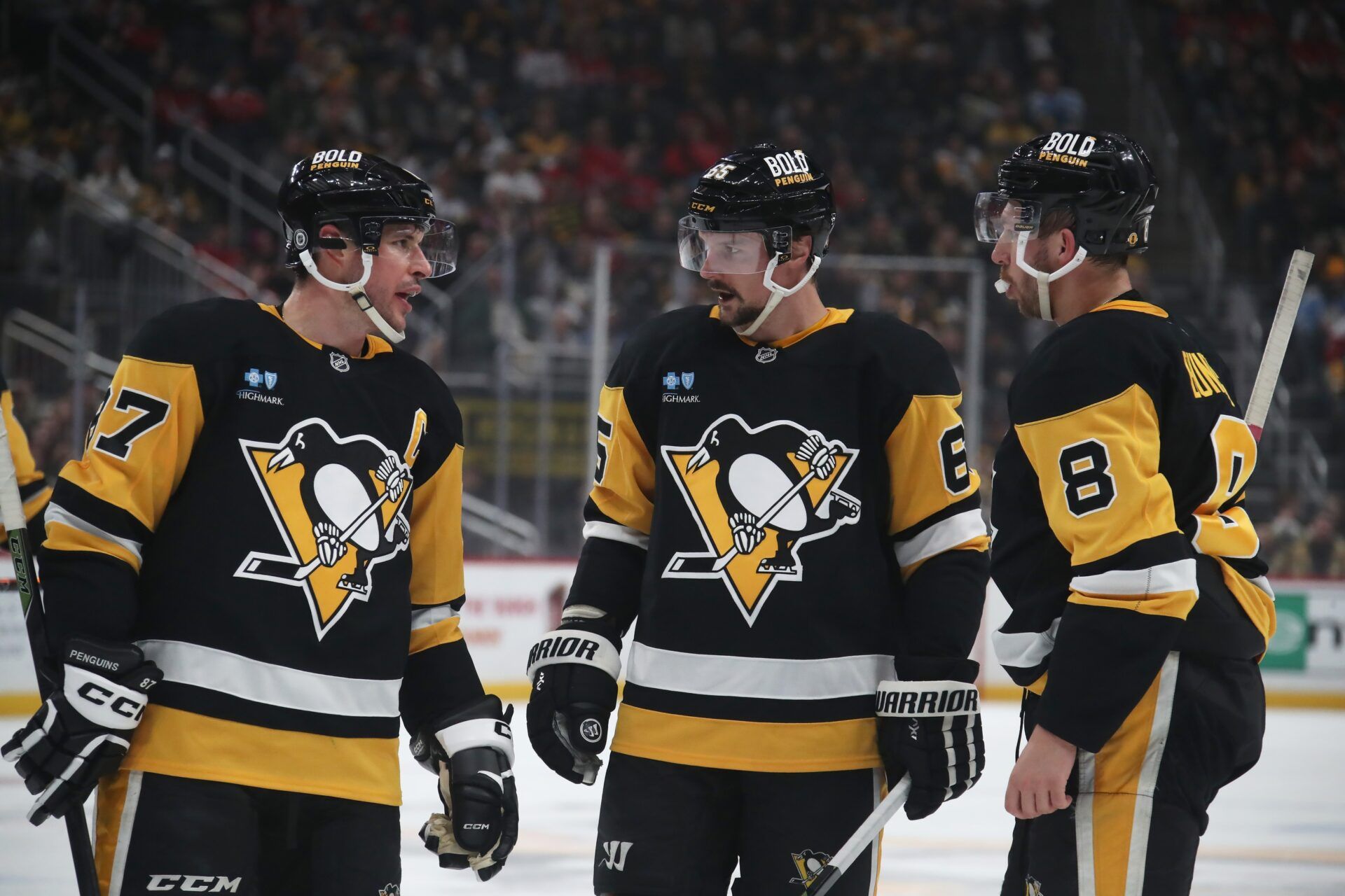 Pittsburgh Penguins center Sidney Crosby (87) talks with defenseman Erik Karlsson (65) and left wing Michael Bunting (8) against the Washington Capitals during the first period at PPG Paints Arena.