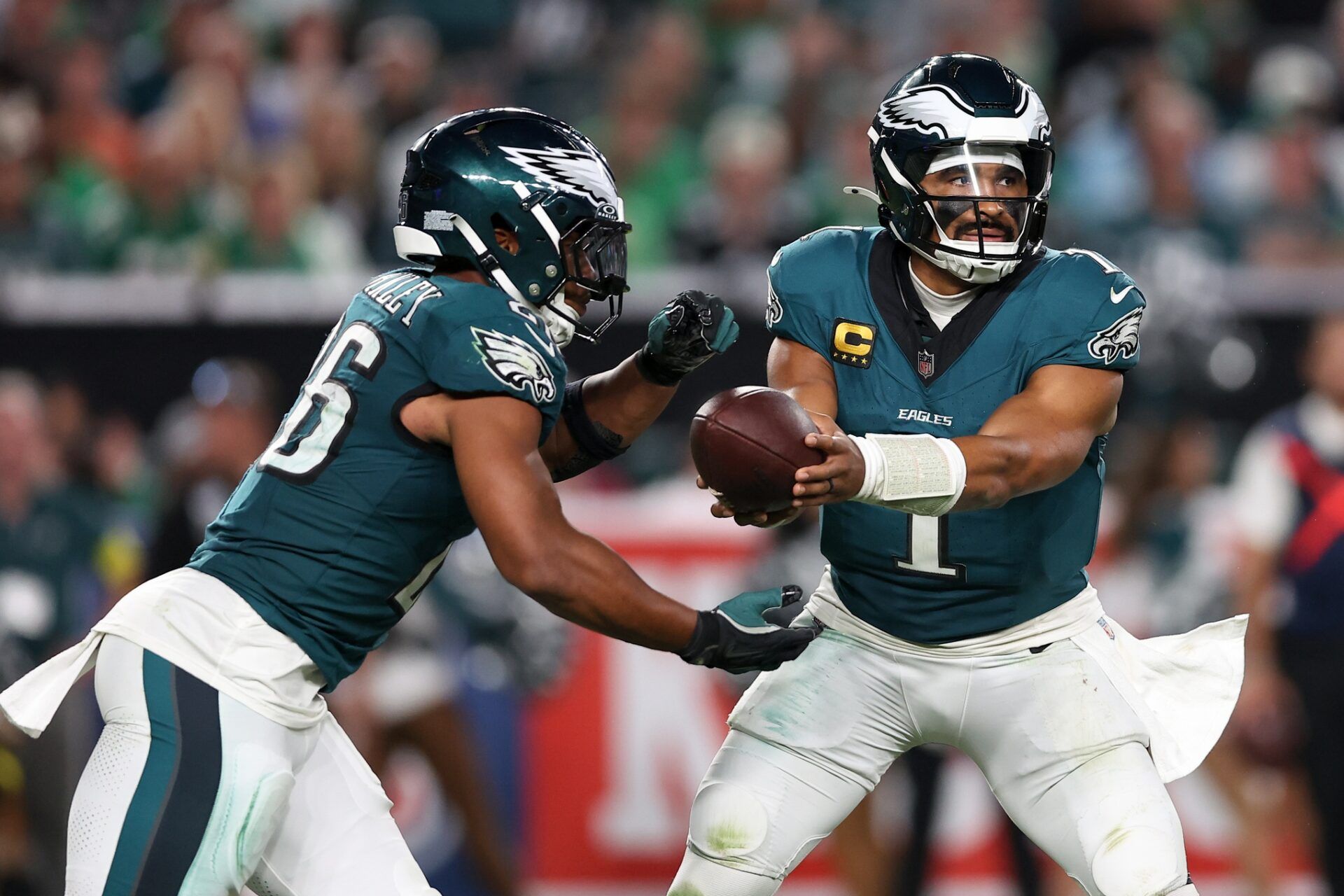 Philadelphia Eagles quarterback Jalen Hurts (1) hands off the ball to running back Saquon Barkley (26) during the third quarter of the game against the Dallas Cowboys at Lincoln Financial Field.