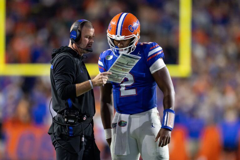 Florida Gators head coach Billy Napier and Florida Gators quarterback DJ Lagway (2) review a play against the Kentucky Wildcats during the second half at Ben Hill Griffin Stadium.