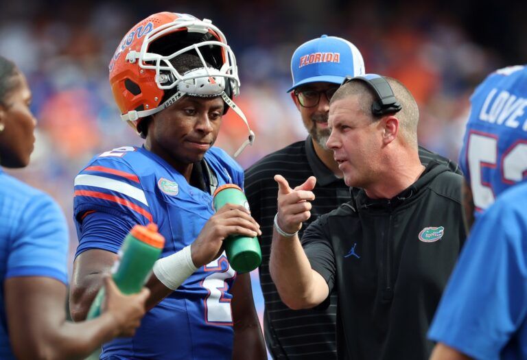 Florida Gators head coach Billy Napier talks with Florida Gators quarterback DJ Lagway (2) against the South Florida Bulls during the first quarter at Ben Hill Griffin Stadium.