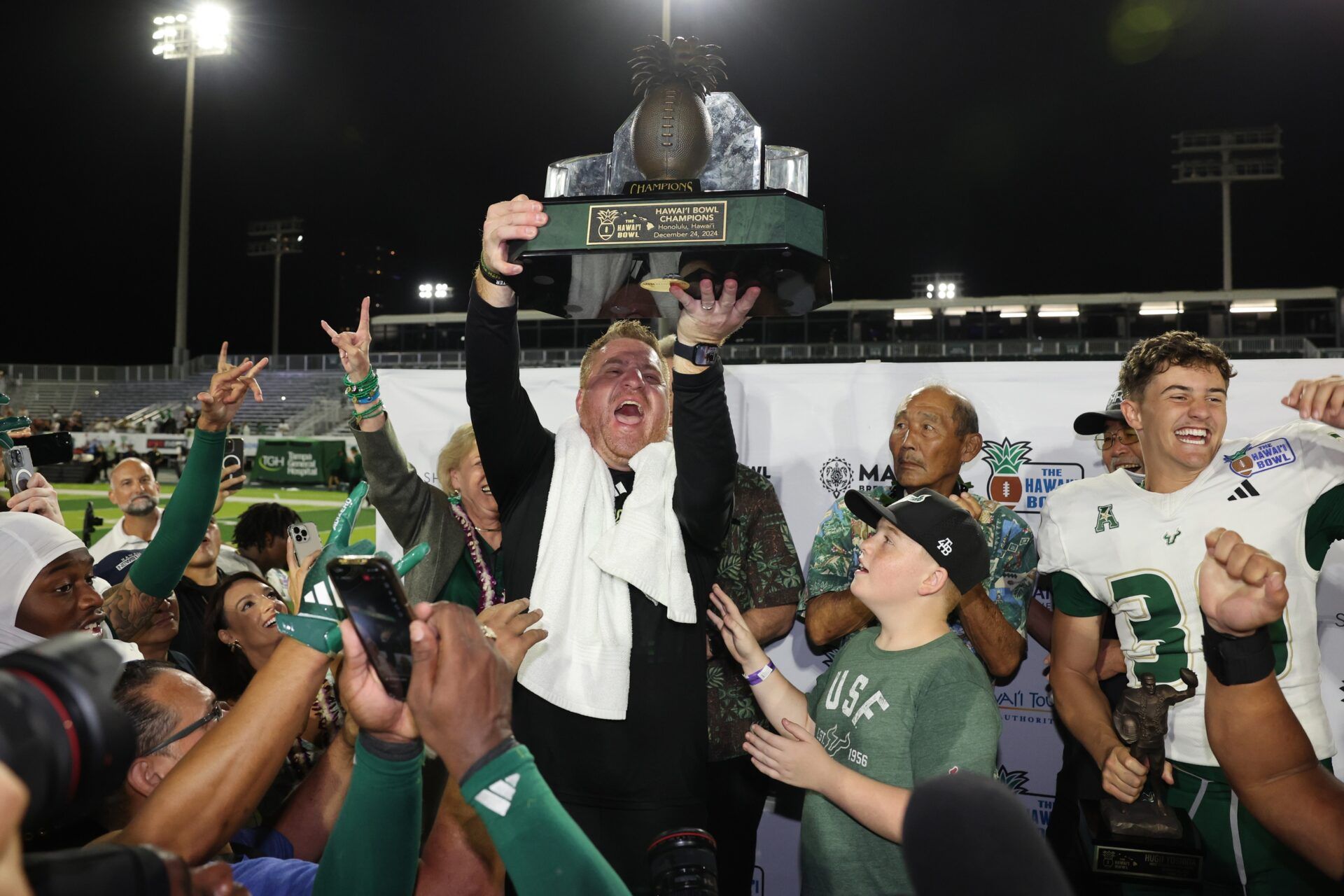 Dec 24, 2024; South Florida Bulls head coach Alex Golesh lifts the winning trophy after his team defeated the San Jose State Spartans in five overtimes at Clarence T.C. Ching Athletics Complex.