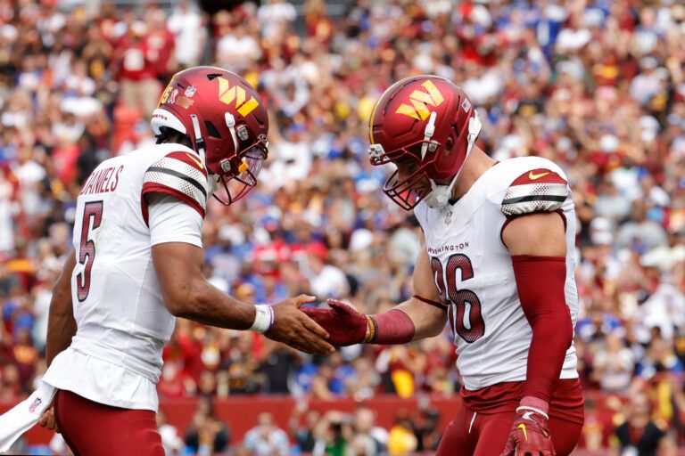 Washington Commanders tight end Zach Ertz (86) celebrates with Commanders quarterback Jayden Daniels (5) after scoring a touchdown against the New York Giants during the first quarter at Northwest Stadium.