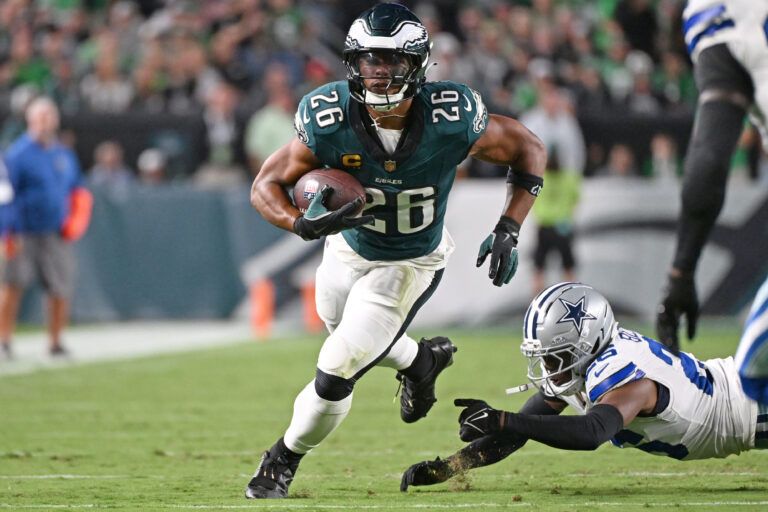 Philadelphia Eagles running back Saquon Barkley (26) runs past Dallas Cowboys cornerback DaRon Bland (26) at Lincoln Financial Field.