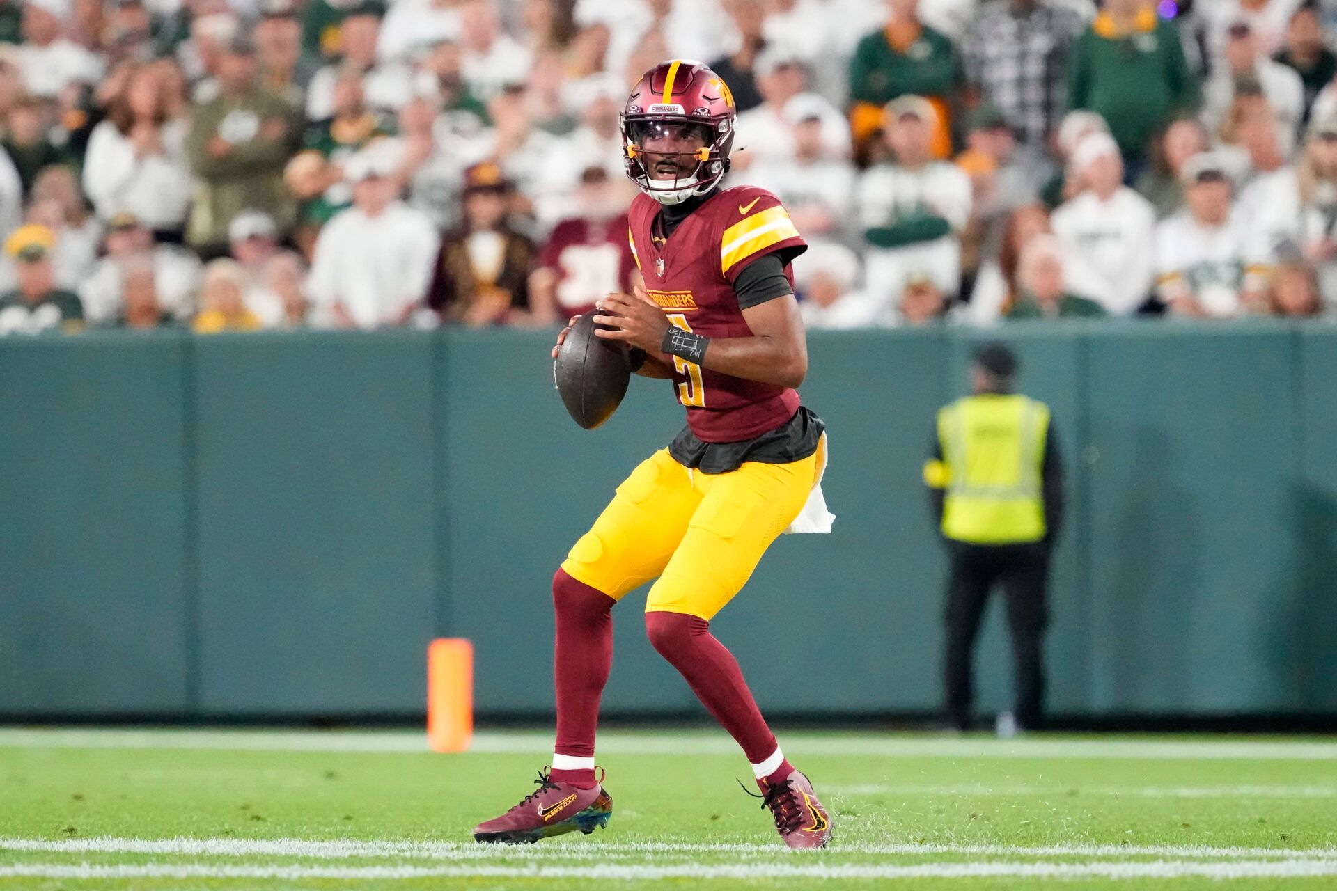 Washington Commanders quarterback Jayden Daniels (5) looks to pass against the Green Bay Packers in the second quarter  at Lambeau Field.