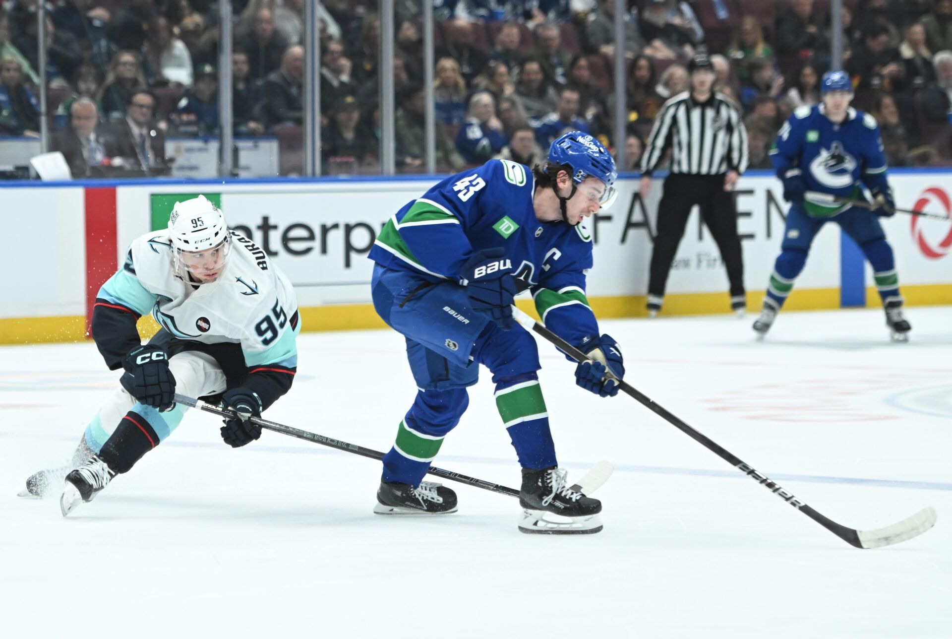 Seattle Kraken forward Andre Burakovsky (95) checks Vancouver Canucks defenseman Quinn Hughes (43) during the first period at Rogers Arena.
