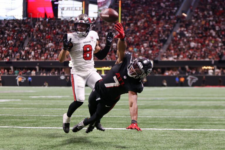 Atlanta Falcons running back Bijan Robinson (7) reaches for the ball against Tampa Bay Buccaneers linebacker SirVocea Dennis (8) during the fourth quarter at Mercedes-Benz Stadium.