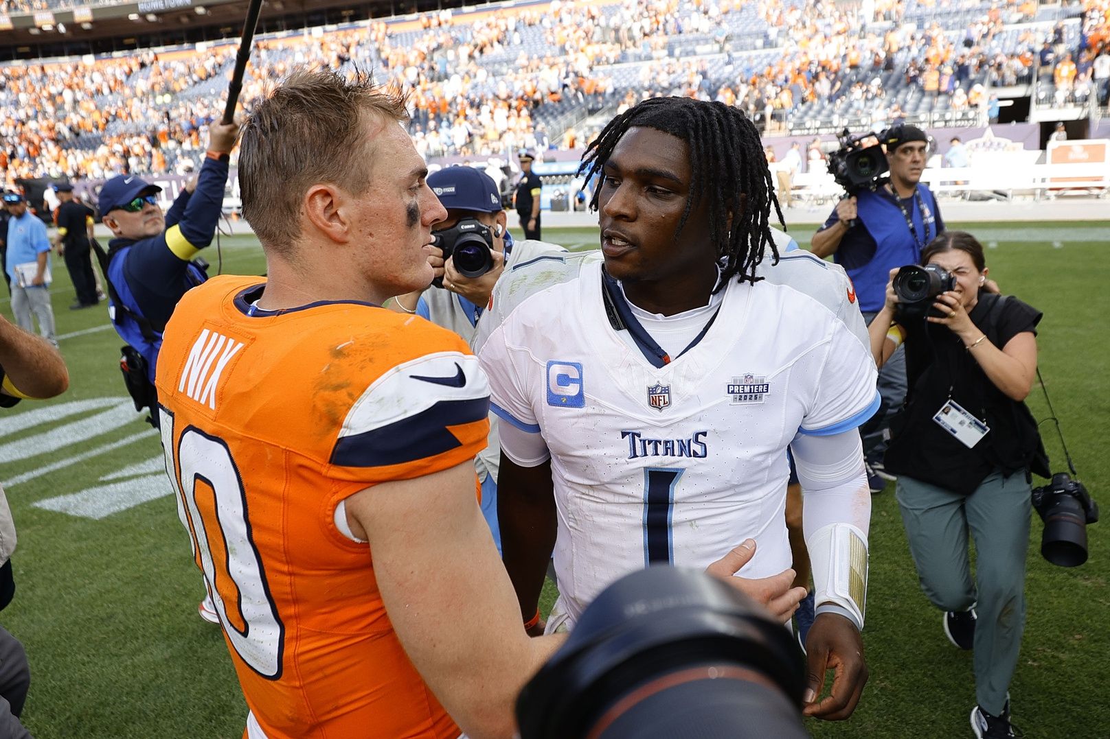 Denver Broncos quarterback Bo Nix (10) and Tennessee Titans quarterback Cam Ward (1) shake hands after the game at Empower Field at Mile High.