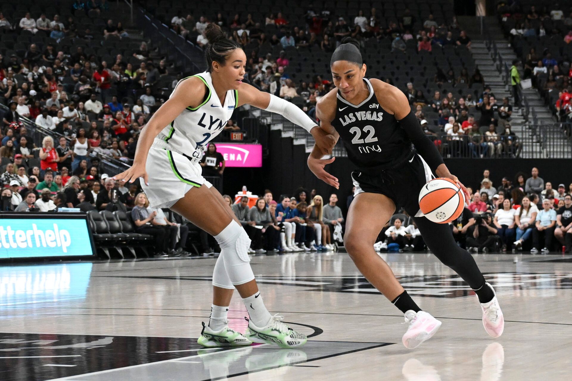 Las Vegas Aces center A'ja Wilson (22) drives past Minnesota Lynx forward Napheesa Collier (24) in the first quarter of their game at T-Mobile Arena.