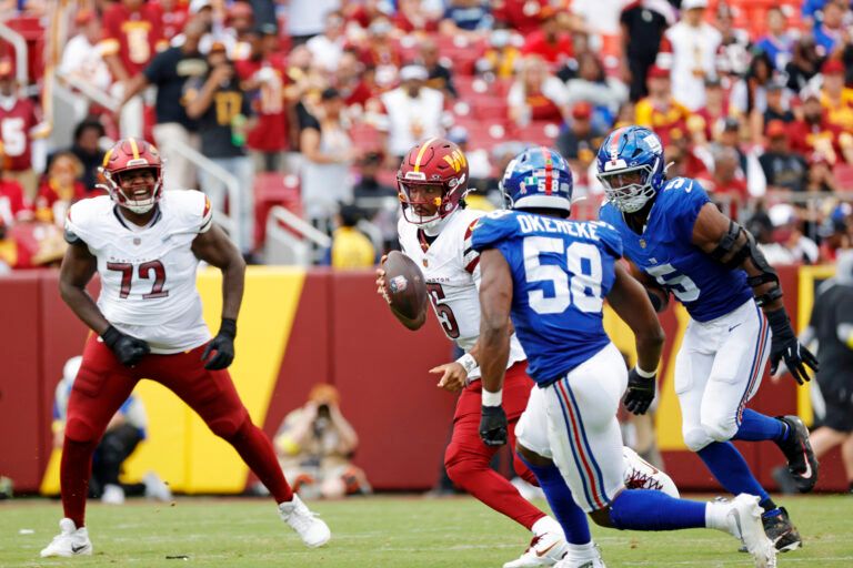 Washington Commanders quarterback Jayden Daniels (5) runs the ball during the third quarter against the New York Giants at Northwest Stadium.