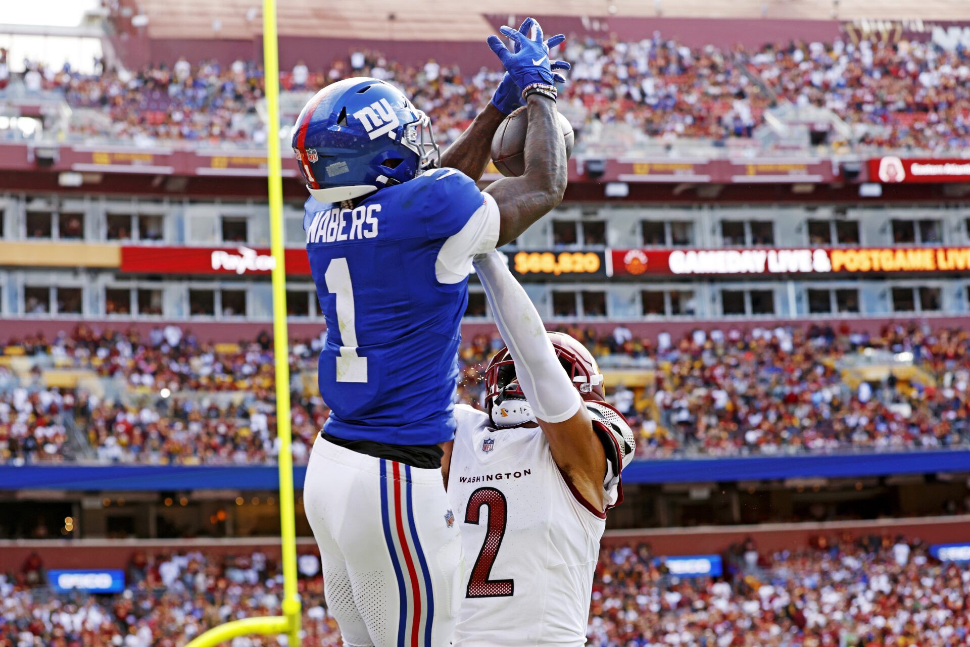 New York Giants wide receiver Malik Nabers (1) jumps up to make a catch during the fourth quarter against the Washington Commanders at Northwest Stadium.