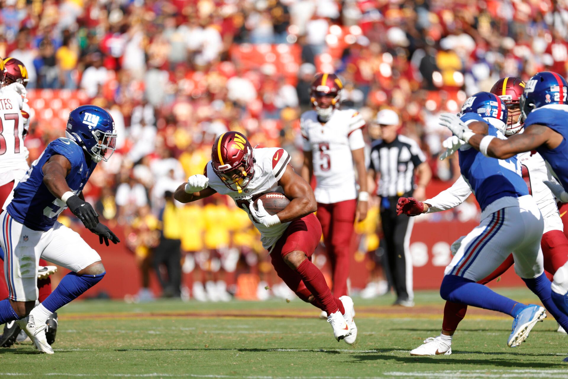 Washington Commanders running back Jeremy McNichols (26) runs with the ball against the New York Giants during the third quarter at Northwest Stadium.