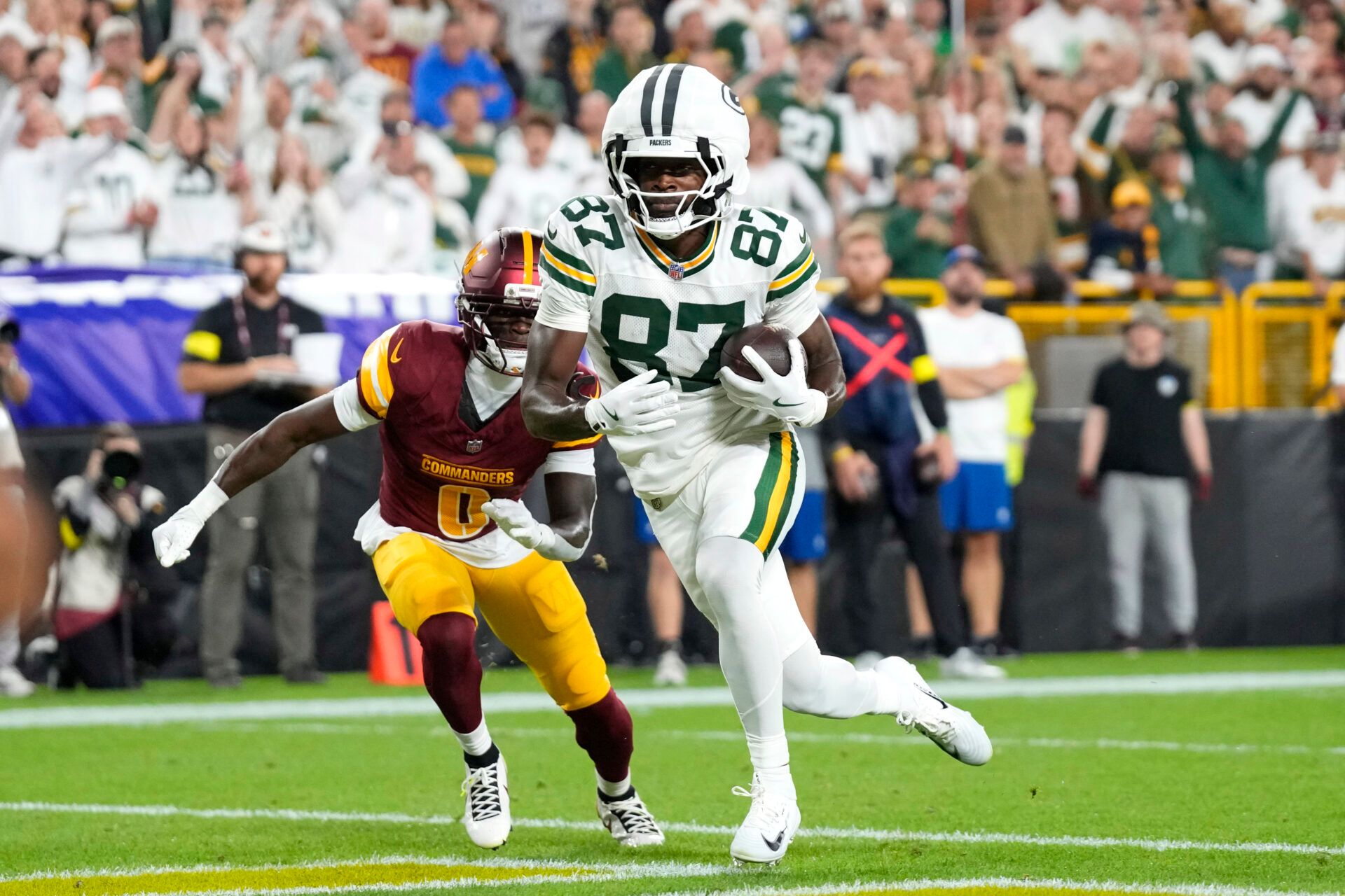 Green Bay Packers wide receiver Romeo Doubs (87) scores a touchdown against Washington Commanders cornerback Mike Sainristil (0) in the first quarter at Lambeau Field.