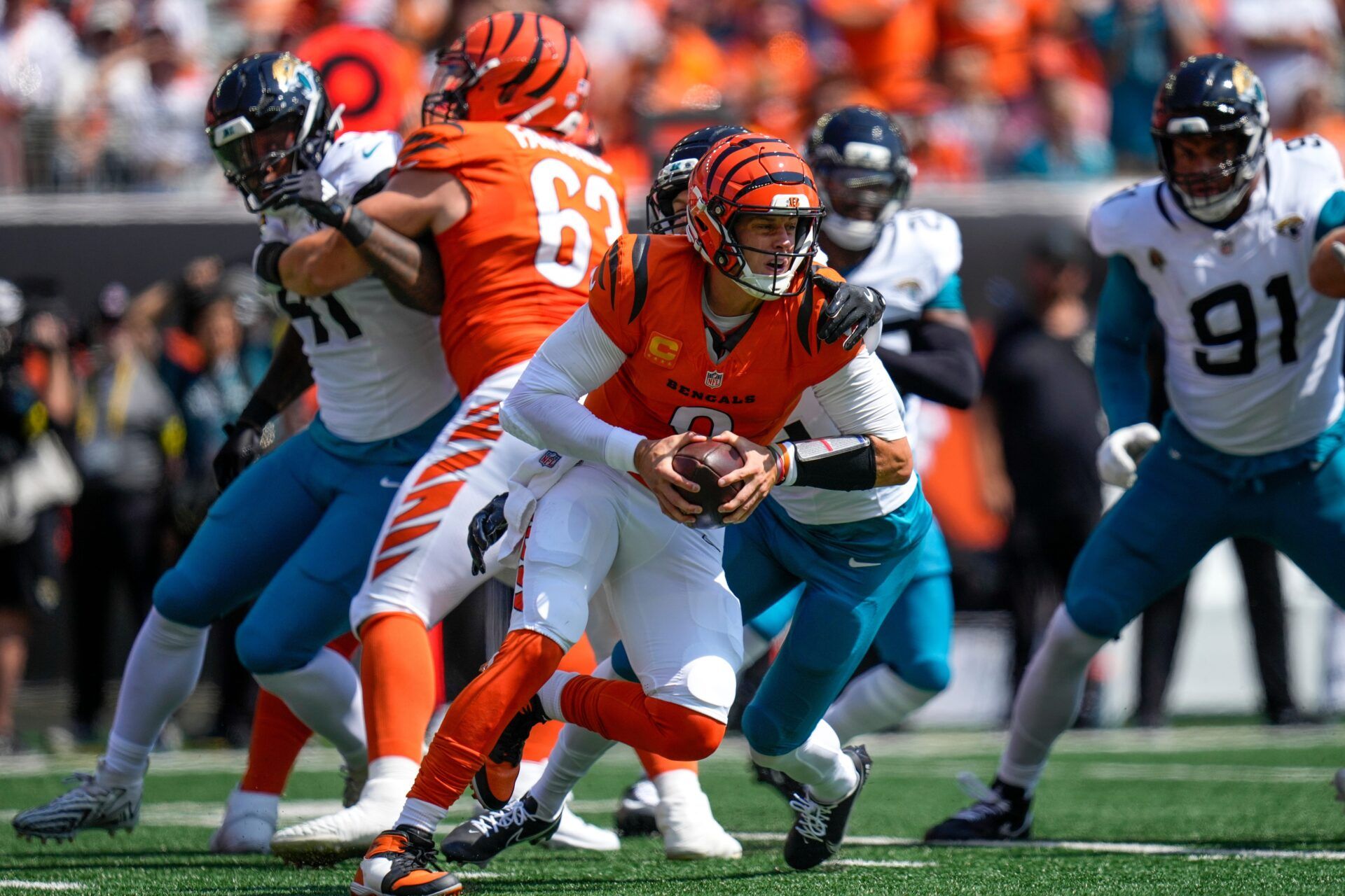 Cincinnati Bengals quarterback Joe Burrow (9) is wrapped up as he scrambles in the first quarter of the NFL Week 2 game between the Cincinnati Bengals and the Jacksonville Jaguars at Paycor Stadium in downtown Cincinnati on Sunday, Sept. 14, 2025. The Jaguars led 17-10 at halftime.