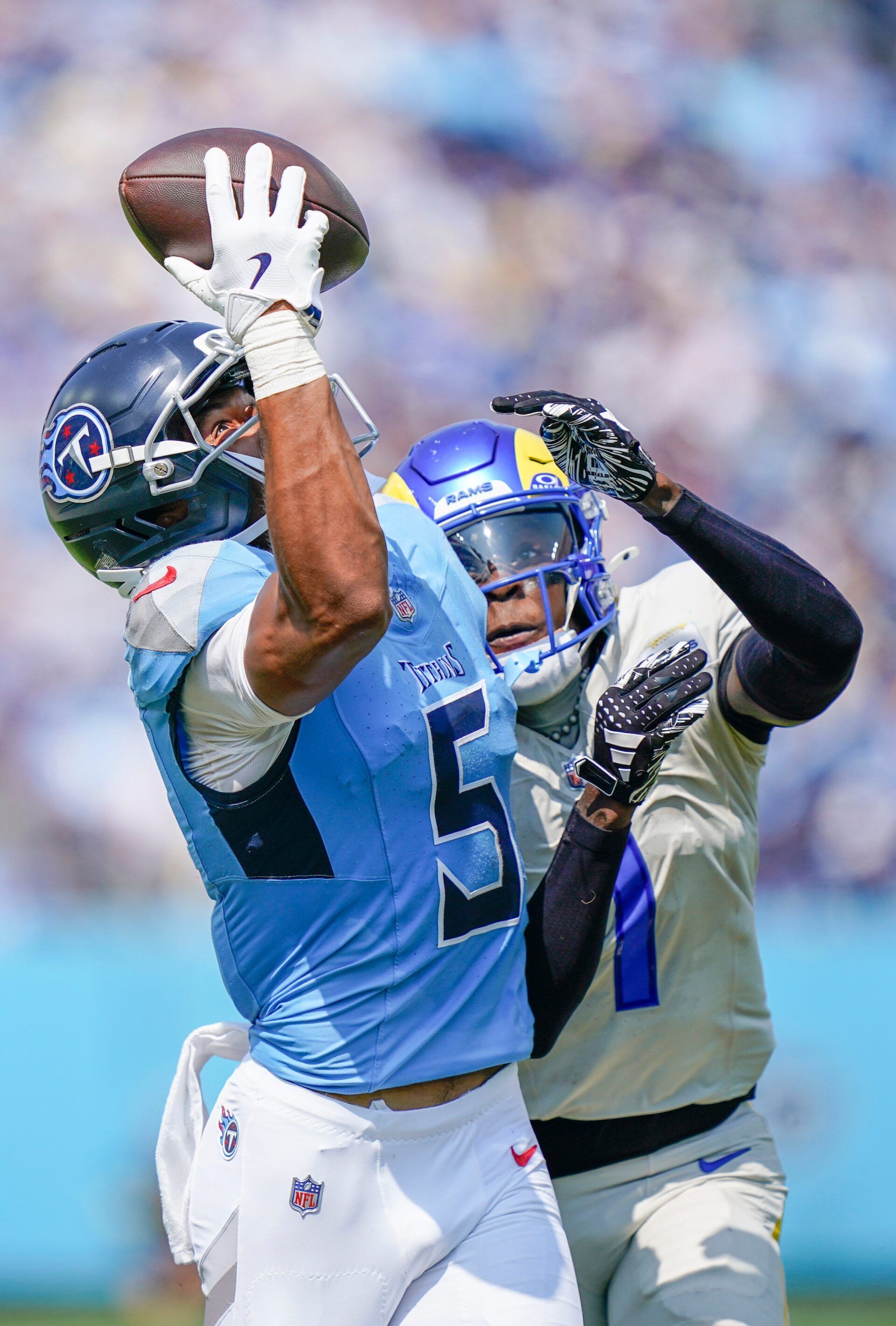 Tennessee Titans wide receiver Elic Ayomanor (5) catches the ball over tight coverage from Los Angeles Rams cornerback Emmanuel Forbes Jr. (1) during the second quarter at Nissan Stadium in Nashville, Tenn., Sunday, Sept. 14, 2025.